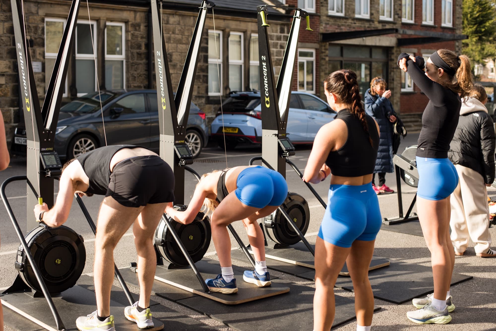 Members on ski ergs at an outdoor community event